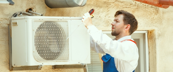 HVAC technician working on a capacitor part for condensing unit
