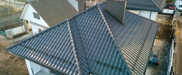 Closeup of house roof top covered with ceramic shingles. Tiled covering of building